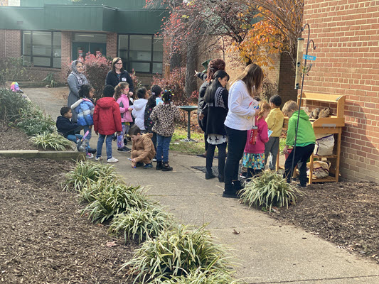 students and teachers learning in the garden