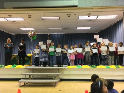 photo of students standing on the stage with certificates in hand.