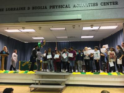 photo of students standing on the stage with certificates in hand.